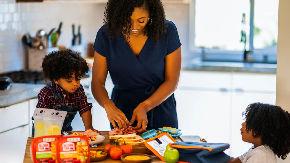 Mum and children at kitchen table making sandwiches