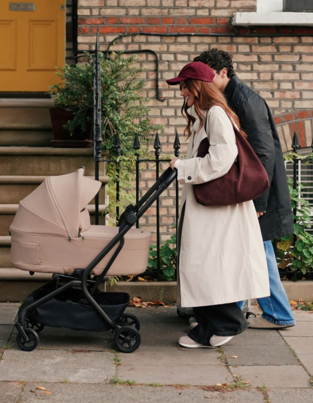 Mum and dad pushing Silvercross pram on cobbled pavement