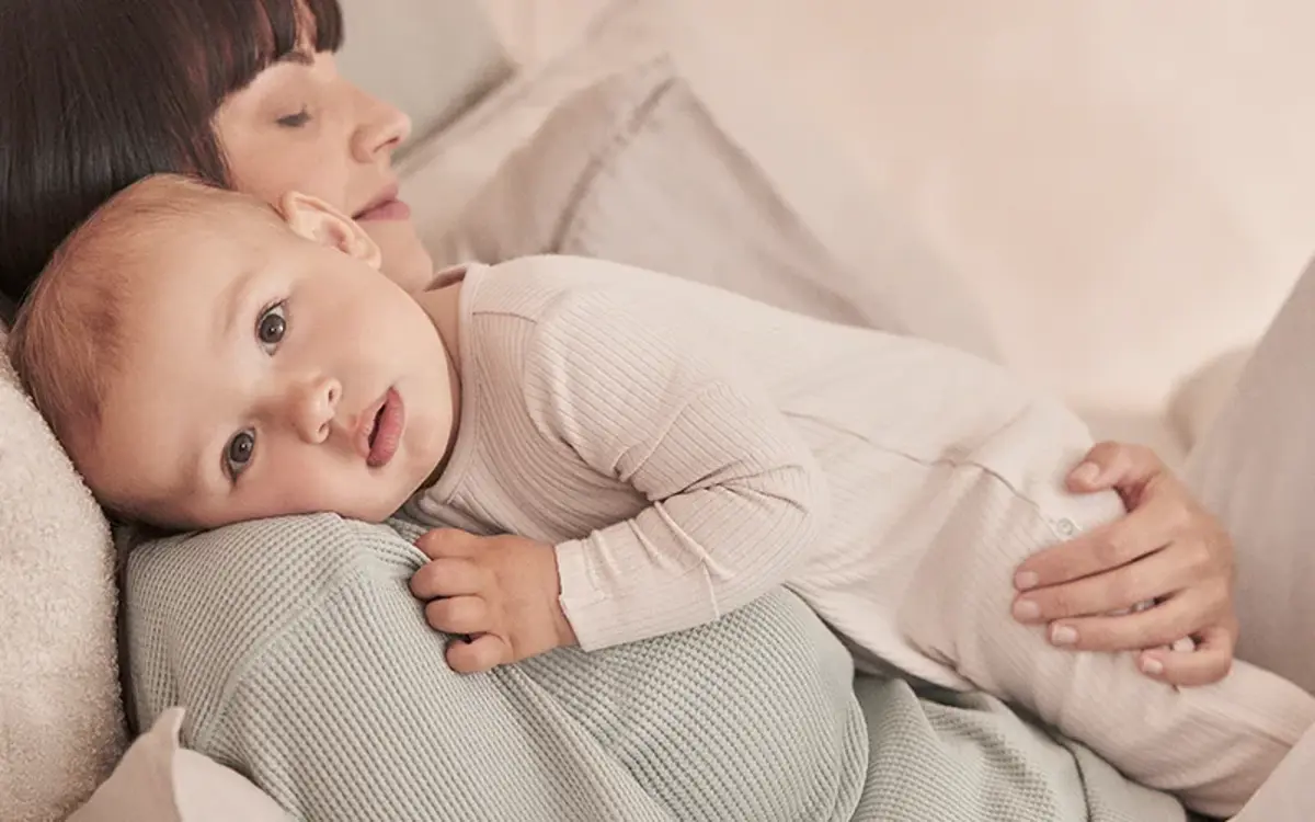 A mum cuddling her baby in the morning light