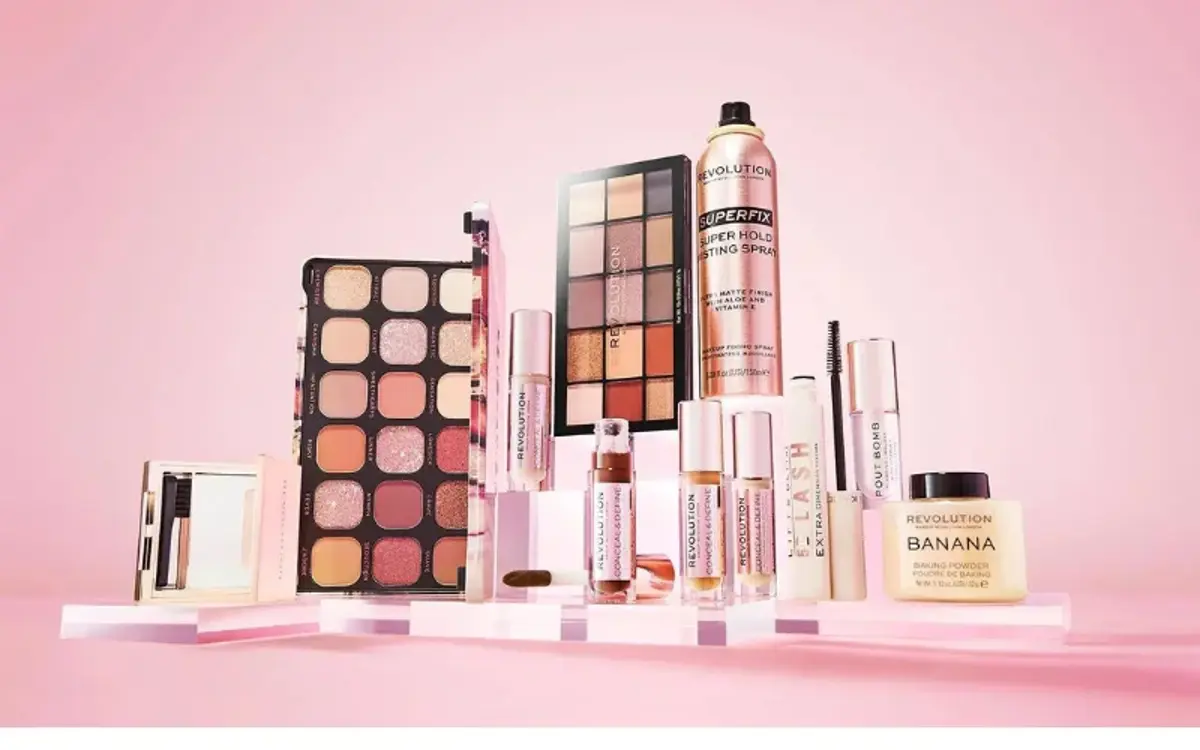 Makeup palettes and cosmetics styled on pink