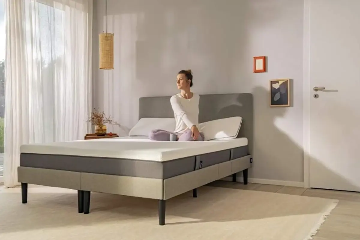 A woman stretching across an Emma mattress