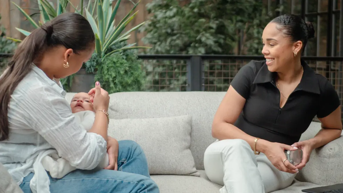 Olivia and Tanyka building Cubbi together on a sofa