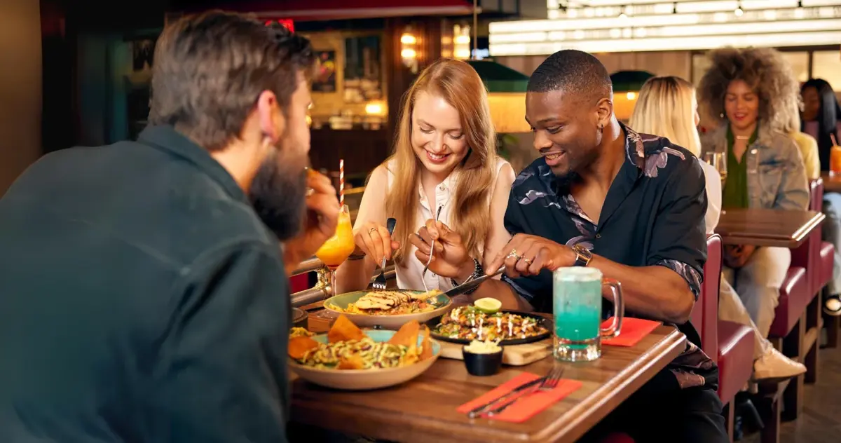 Friends sharing dinner at a busy restaurant