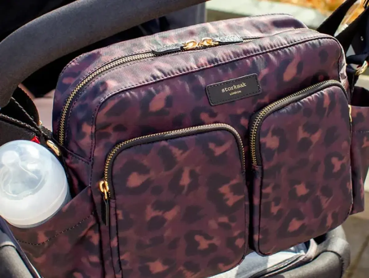 A leopard-print changing bag clipped to a pram