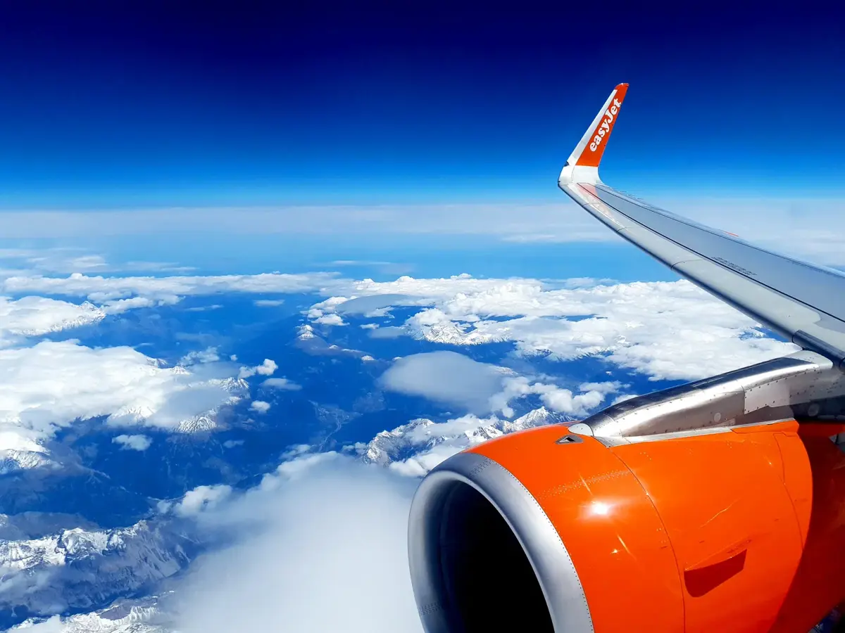 A plane wing above the clouds from the window seat