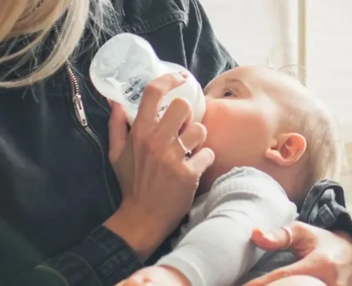 A parent bottle-feeding their baby