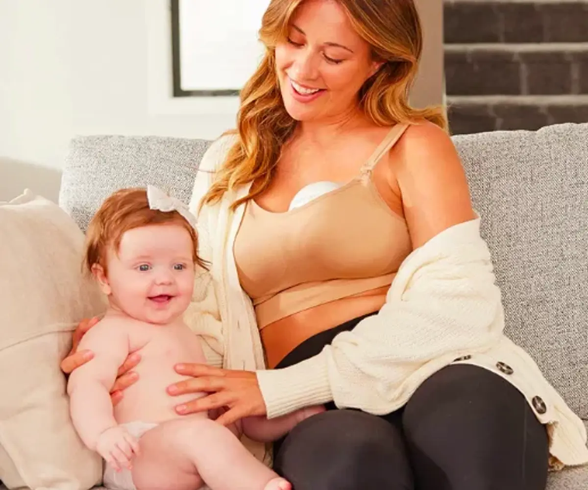 A mum in a nursing bra holding her laughing baby